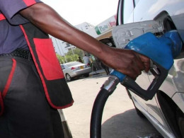 A petrol station attendant fueling a vehicle