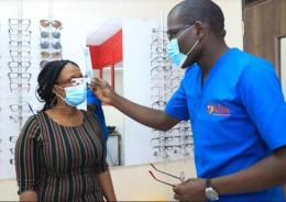 Equity Afia Ngong Road Optometrist Felix Ingati (right) helps a patient to select suitable frames at the clinic’s optical unit.