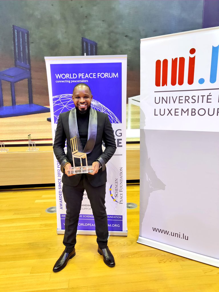 Boniface Mwangi poses with his Outstanding Youth Peacemaker award at the 9th annual Luxembourg Peace Prize ceremony on May 28, 2021. |Courtesy| Twitter|