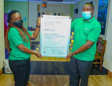 Upfield Kenya head of Regulatory affairs and Nutrition Phylis Obote hands over the FSCC certificate to Managing Director Upfield Eastern and Southern Africa peter Muchiri during a celebration of the awarding of the certification at Upfield Nairobi Offices