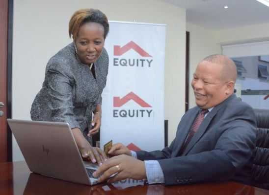 Equity Bank Kenya Managing Director, Gerald Warui (left) looks through the newly revamped American Express (AMEX) Membership Rewards website with Equity Bank Relationship Manager – Card Business, Susan Muigai (right).