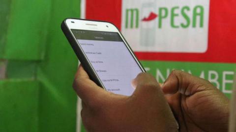 File Image of a client using a mobile money service M-Pesa/Courtesy.