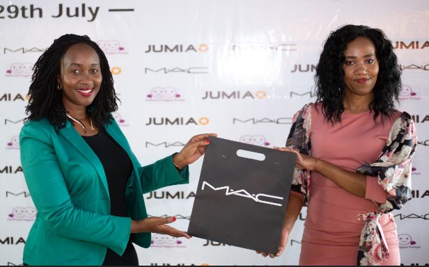 Pauline Masese, Jumia PR Manager, hands a gift hamper from Mac Cosmetics to Terry Wambui (Left) during a recent event organized by Jumia to celebrate the Cleft lip and palate women in Kenya ahead of National Lipstick Day this week.