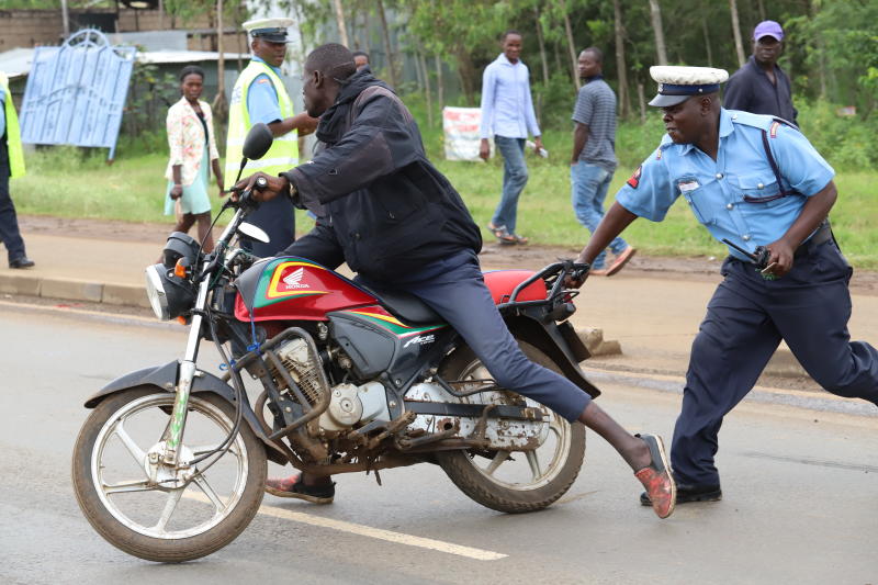 File image of a police officer attempting to apprehend a boda boda rider. |Photo| Courtesy|