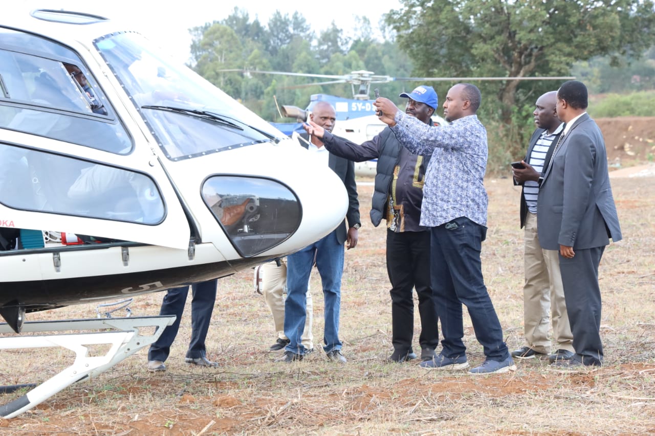 Raila Odinga and Junet Mohamed looking at the stoned chopper in Uasin Gishu county.  