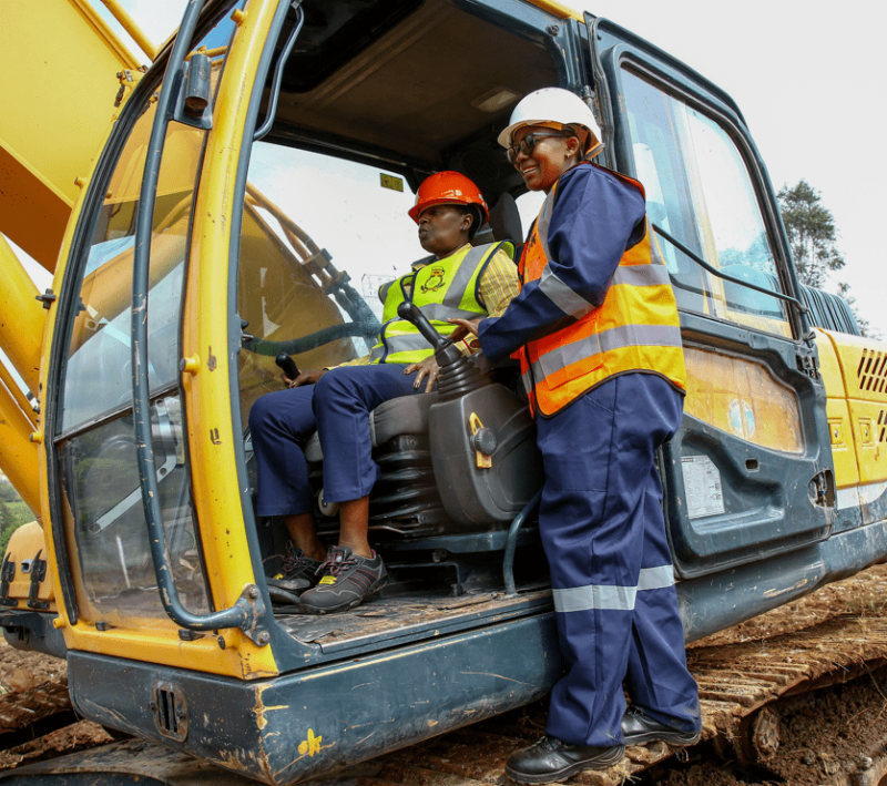 EABL CEO, Jane Karuku tries out the excavator by the operator Lydia Wahu during a ground breaking ceremony of a micro brewery set to be put up at the Ruaraka Headquarters.