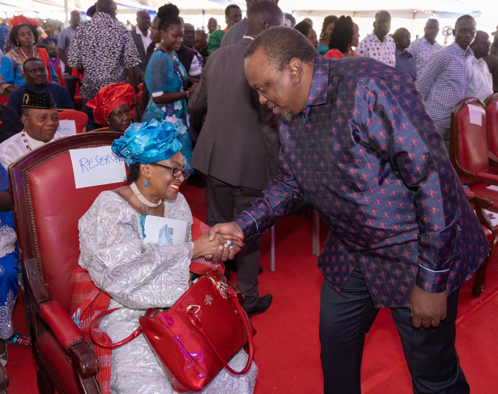 Former President Uhuru Kenyatta shakes hands with Magoha's wife Barbara Odudu Magoha. IMAGE: Nairobi Leo