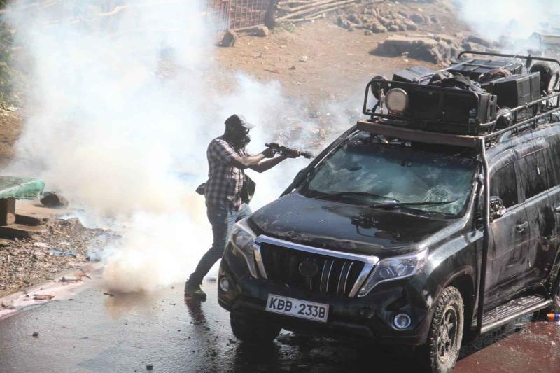A police officer hurling a teargas canister in one of the press vehicles.