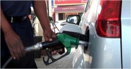 An attendant serving a motorist at a filling station.