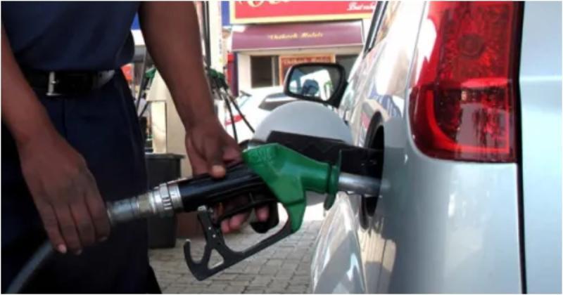 An attendant serving a motorist at a filling station.