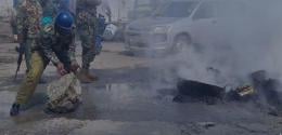 Police officer clearing a road barricaded in Mombasa.