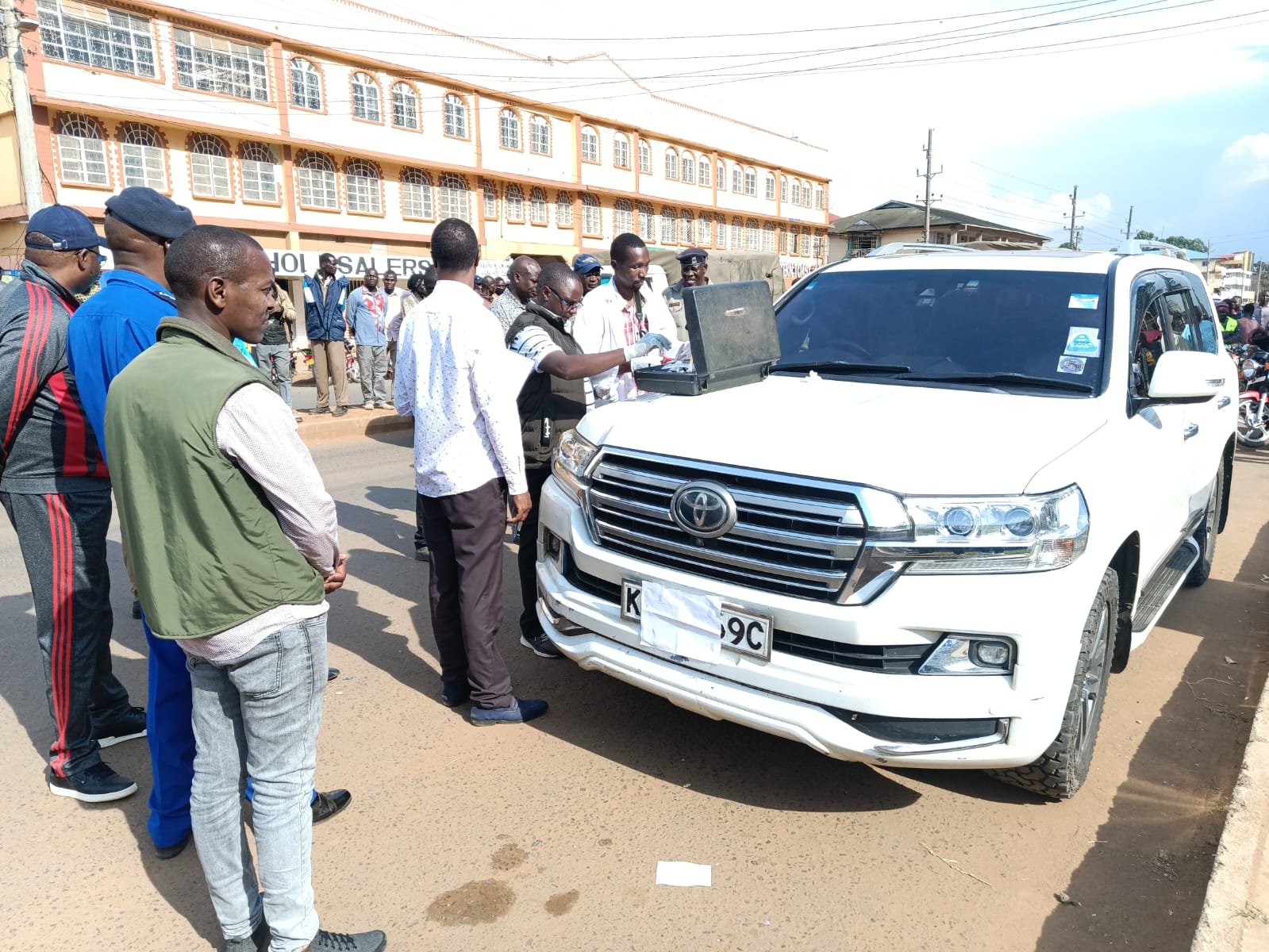 DCI officers conducting forensic analysis on the MP's car.