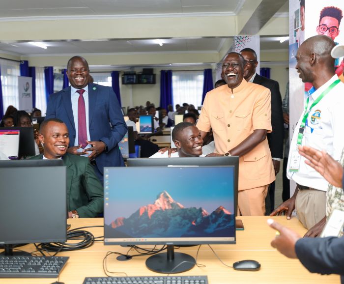 Student showing President William Ruto how his online accounts works.