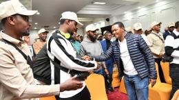 File image of Alfred Mutua interacting with Kenyans flying to Qatar