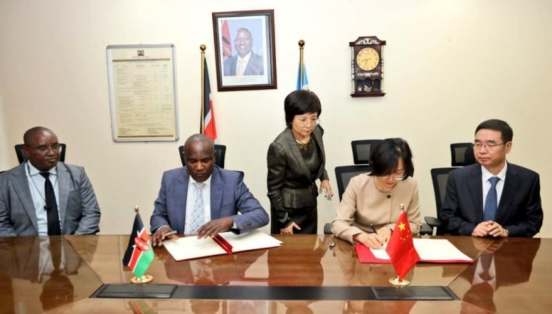 Treasury CS John Mbadi signing an agreement with Chinese Ambassador to Kenya Guo Haiyan.