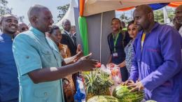 File image of President William Ruto interacting with a Hustler Fund beneficiary
